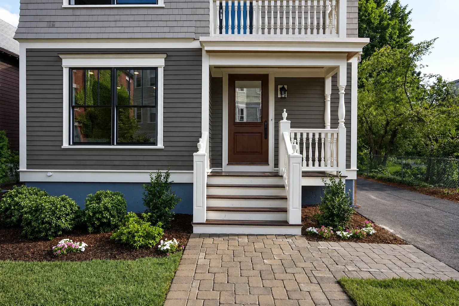 Completed gray home addition with landscaped entry