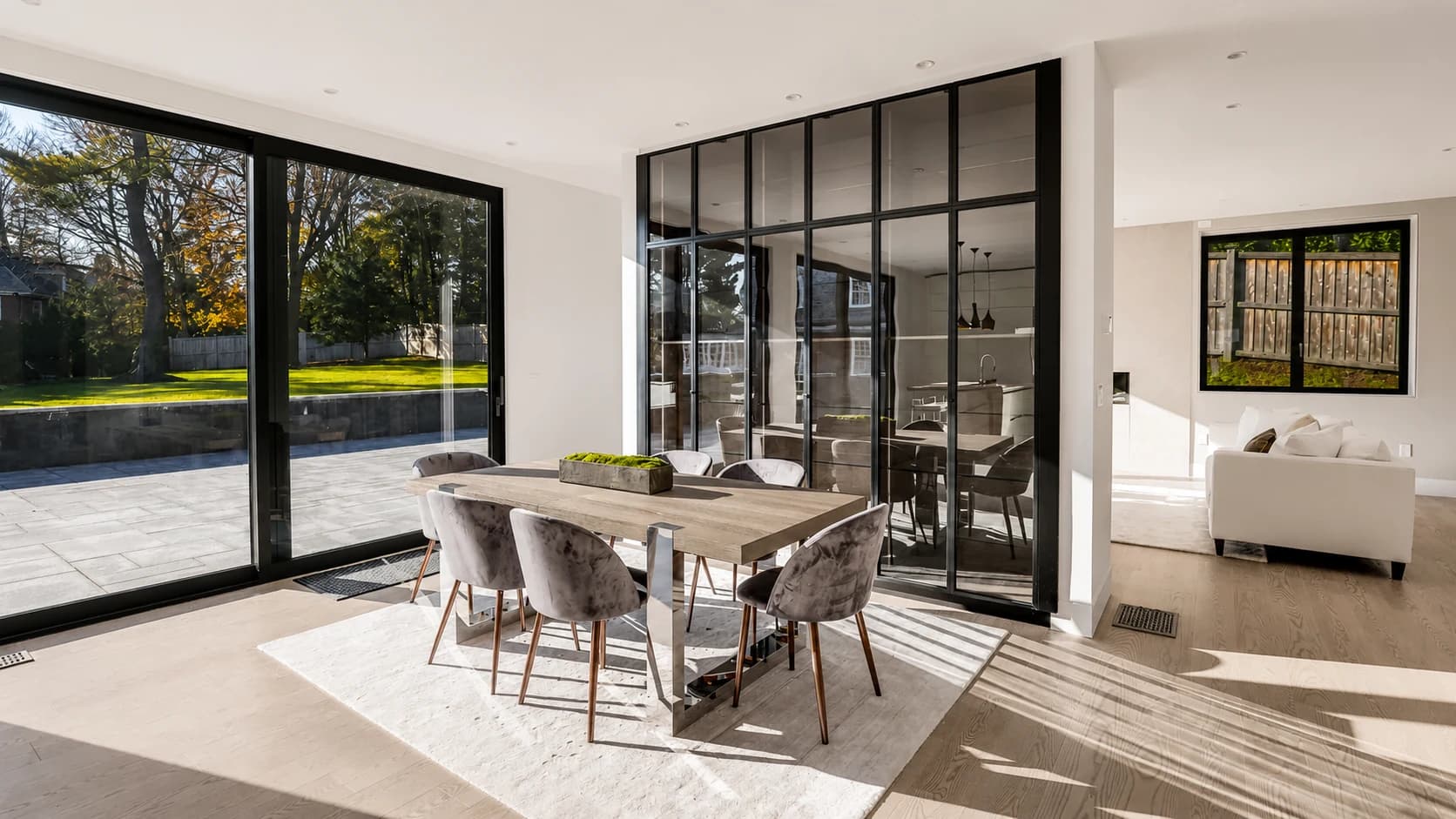 Modern dining room framed by full-height glazing