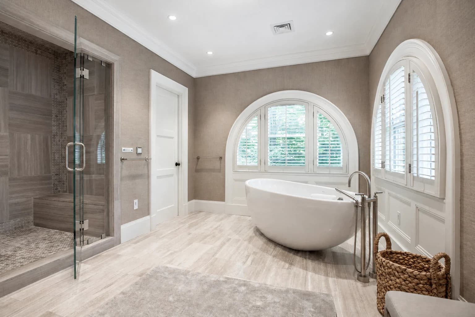 Spa bathroom with freestanding tub and arched windows